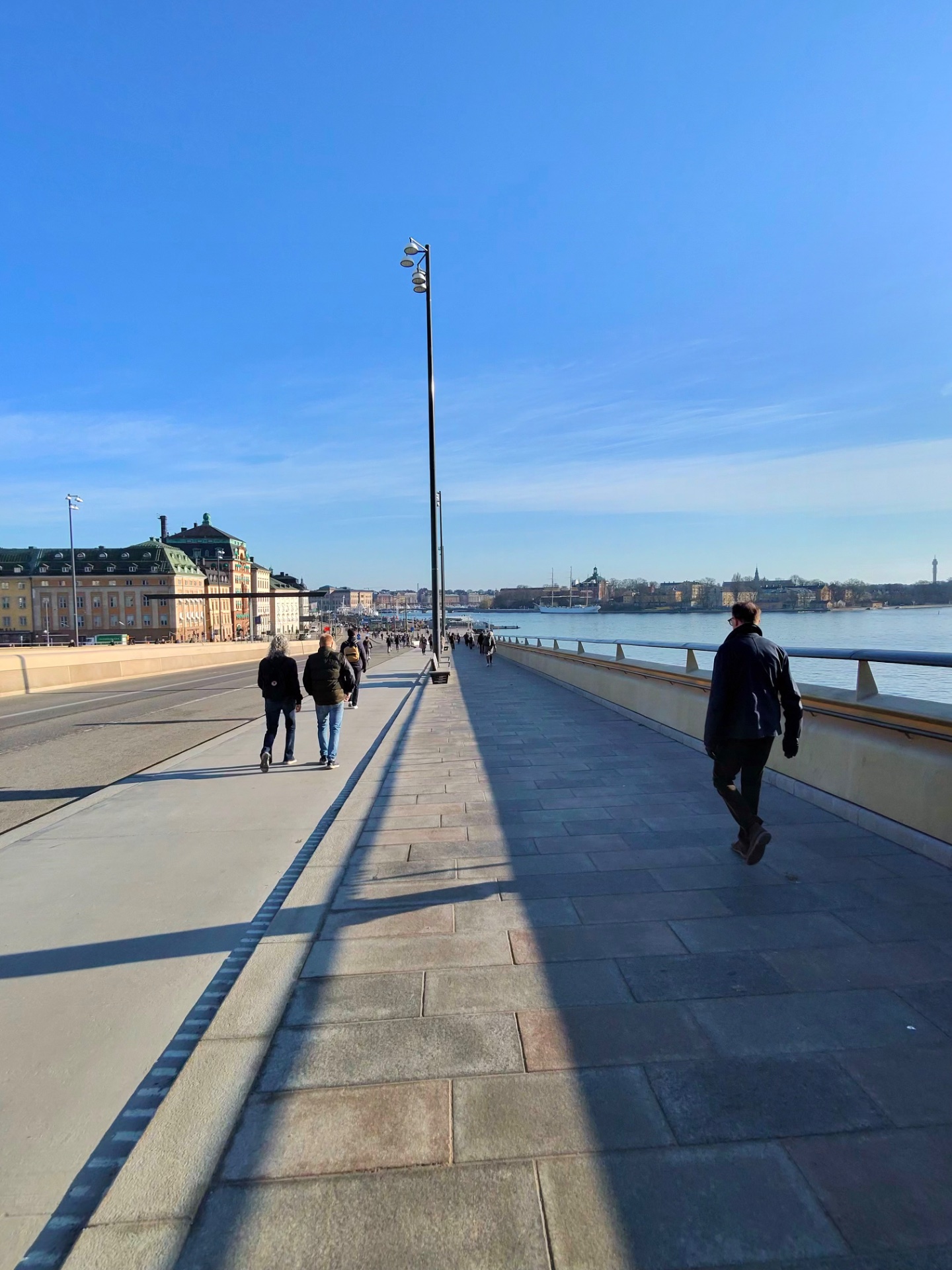 An outdoor waterfront walk or jog along a beautiful scenic promenade with stunning city views and water backdrop. Perfect for a casual cardio session in an urban setting!