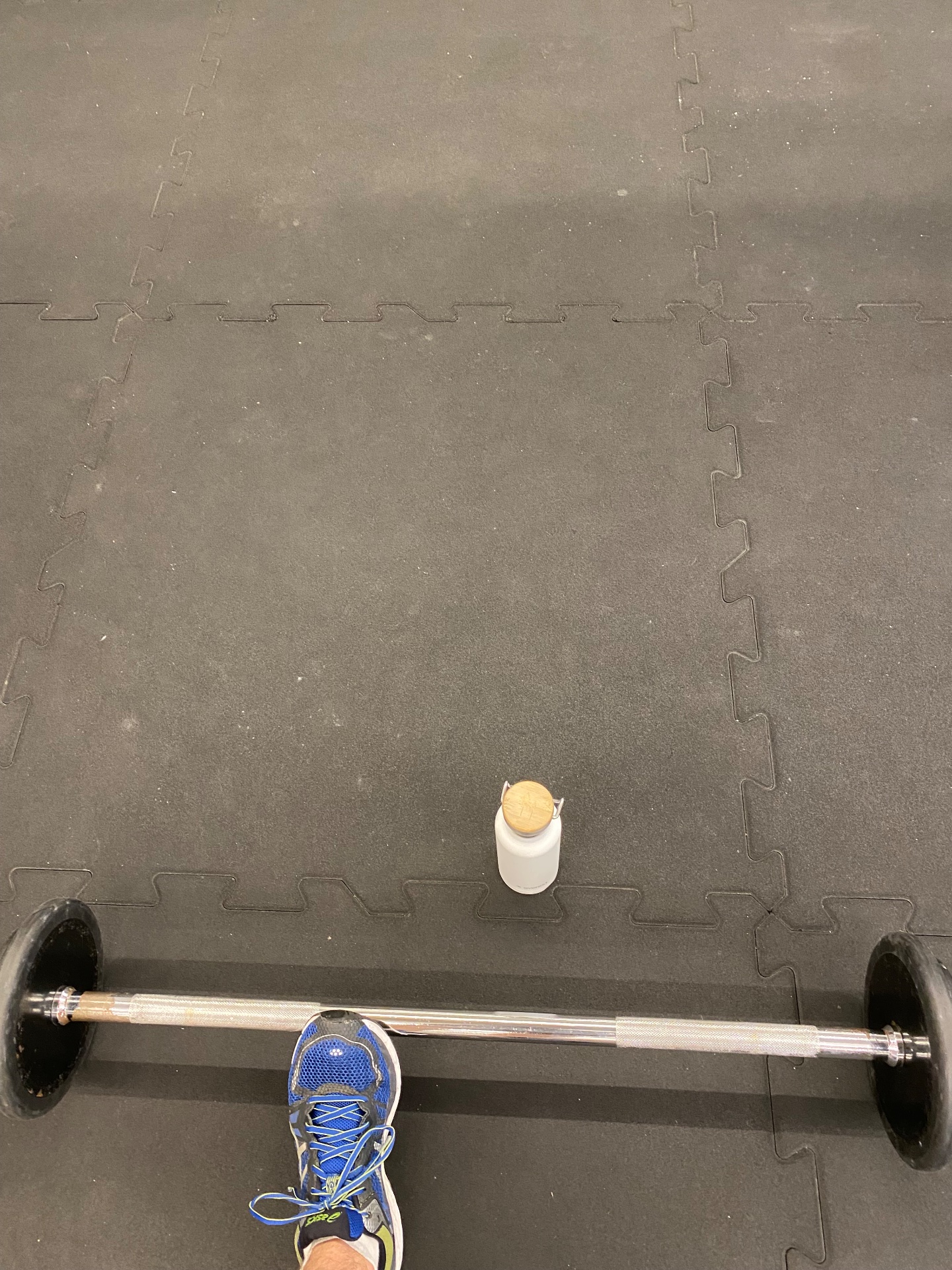 A solid weightlifting session with a loaded barbell on a gym floor! This overhead or floor press setup shows serious strength training in action.