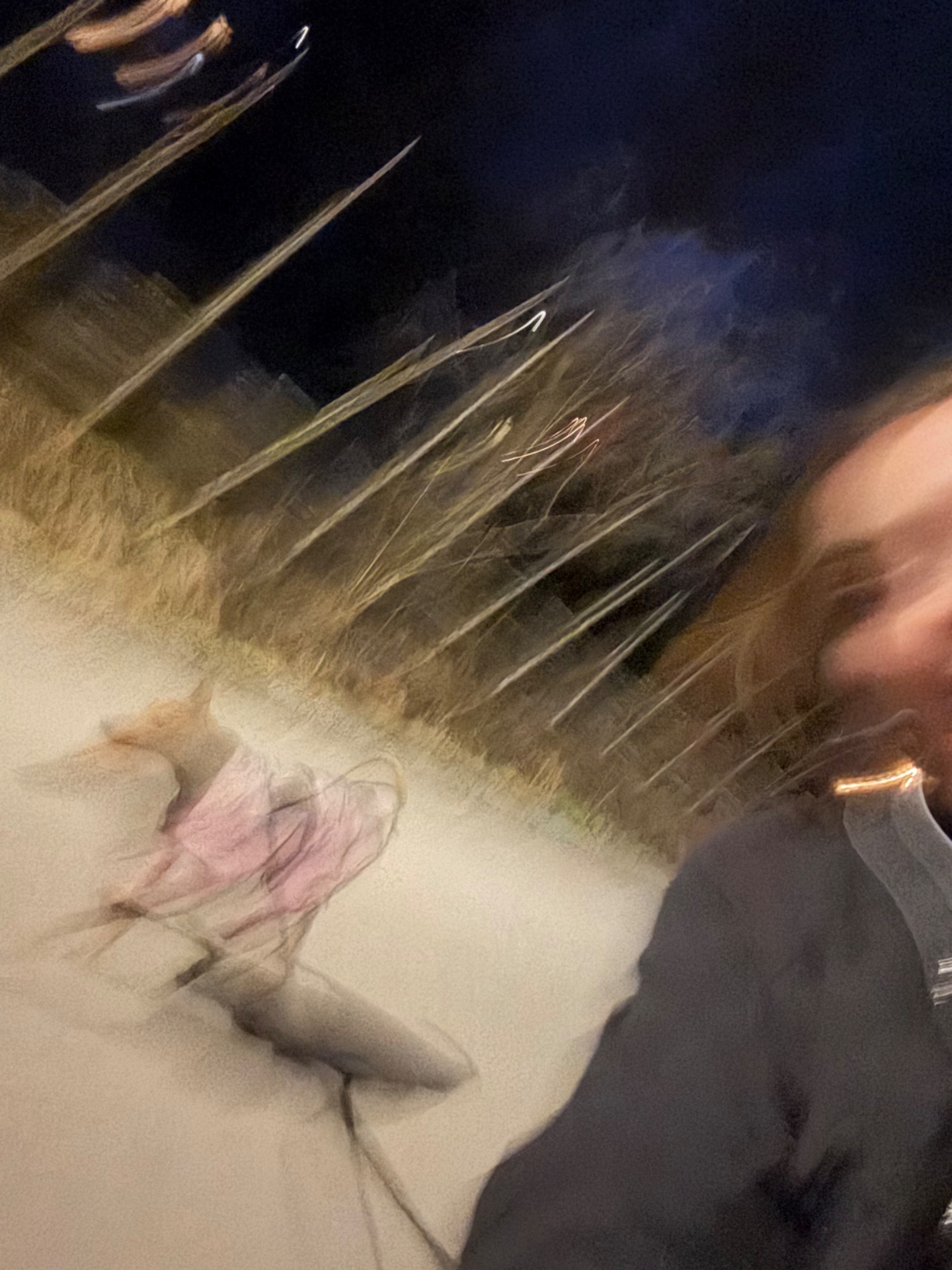 A nighttime outdoor running session captured mid-stride with motion blur, showing someone actively moving through what appears to be a natural terrain or trail environment.