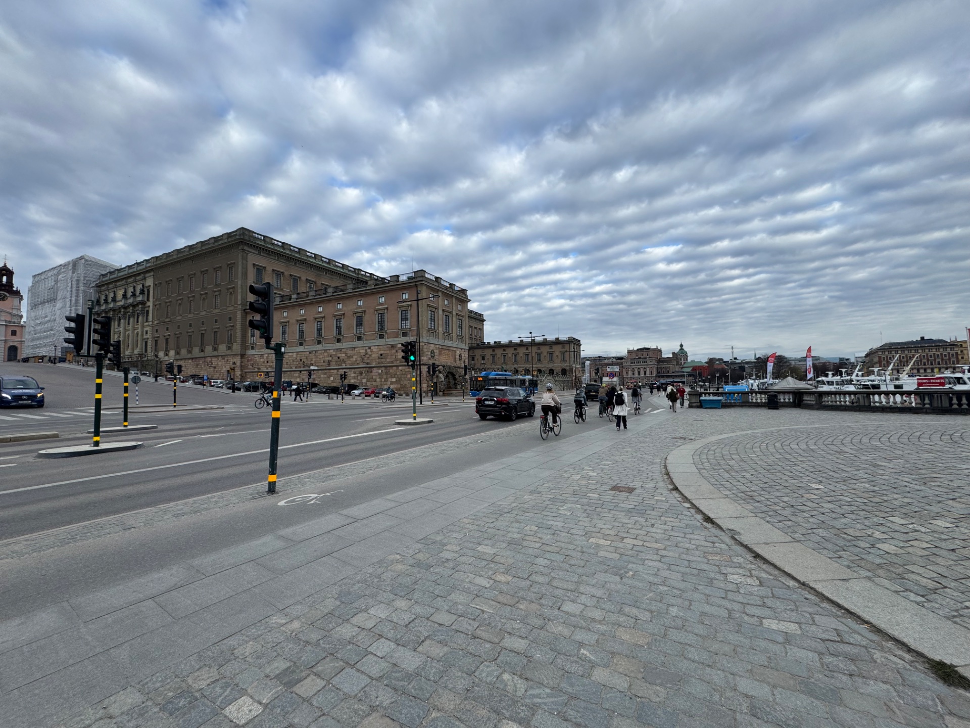 Urban walking or casual cycling through a scenic waterfront plaza in what appears to be a European city. Great for low-intensity cardio and enjoying the outdoors!