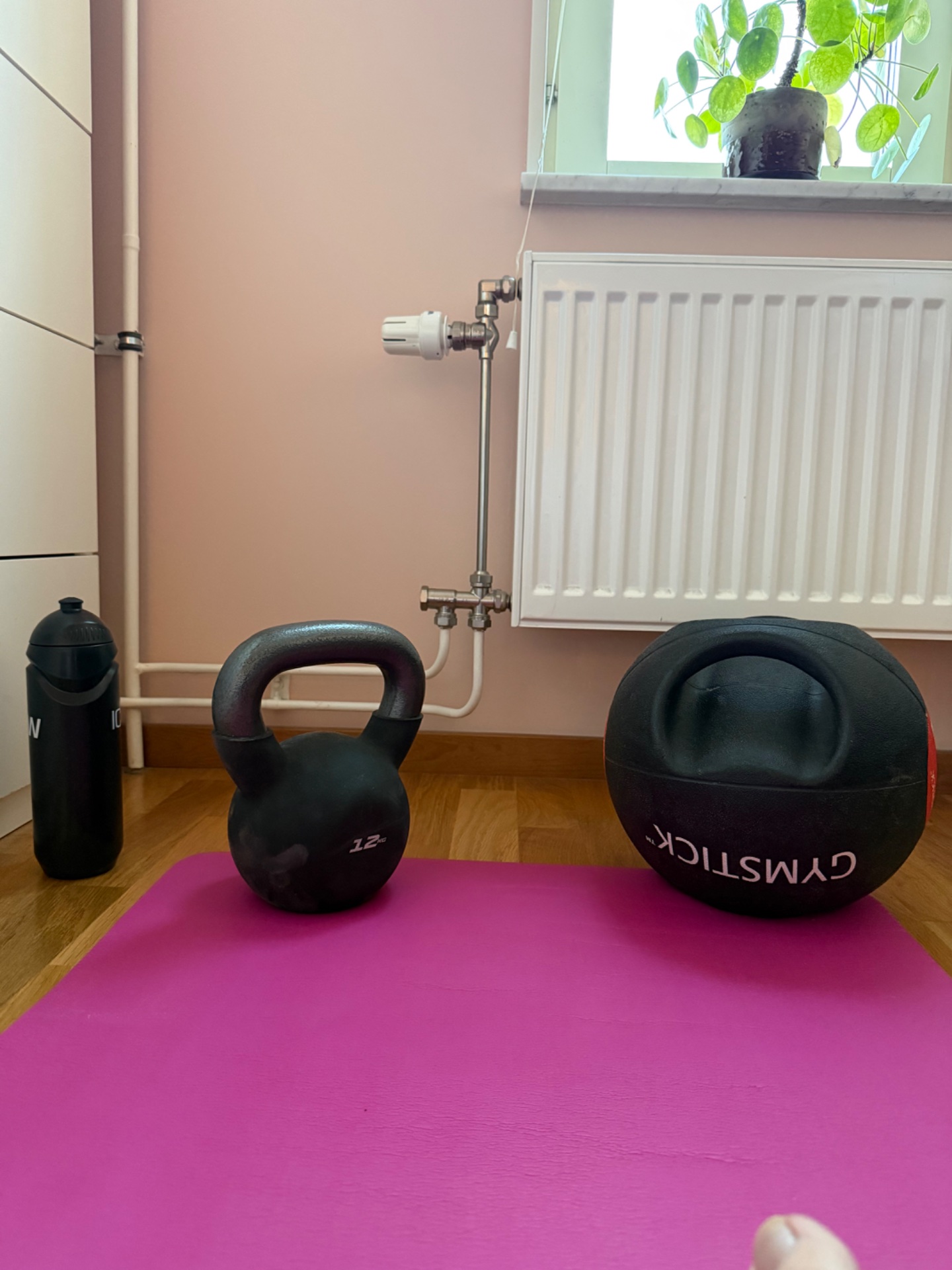 Home strength training setup featuring kettlebells and a medicine ball on a workout mat—perfect for functional fitness and resistance exercises!