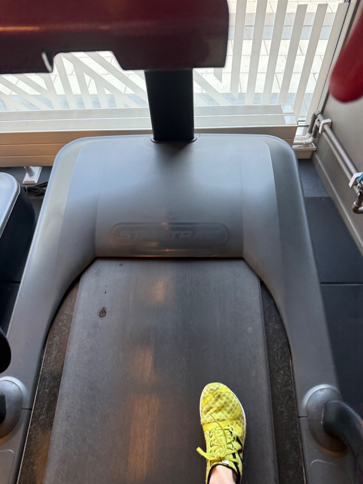Treadmill running session with bright yellow running shoes visible on the belt. A solid indoor cardio workout!
