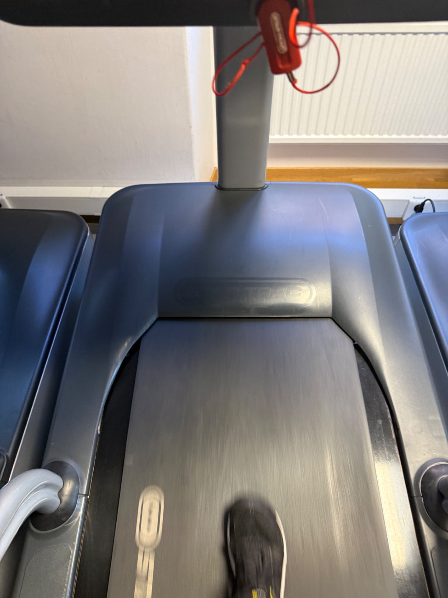 Treadmill running session with headphones ready to go! This is a classic cardio workout setup captured from the runner's perspective on the machine.