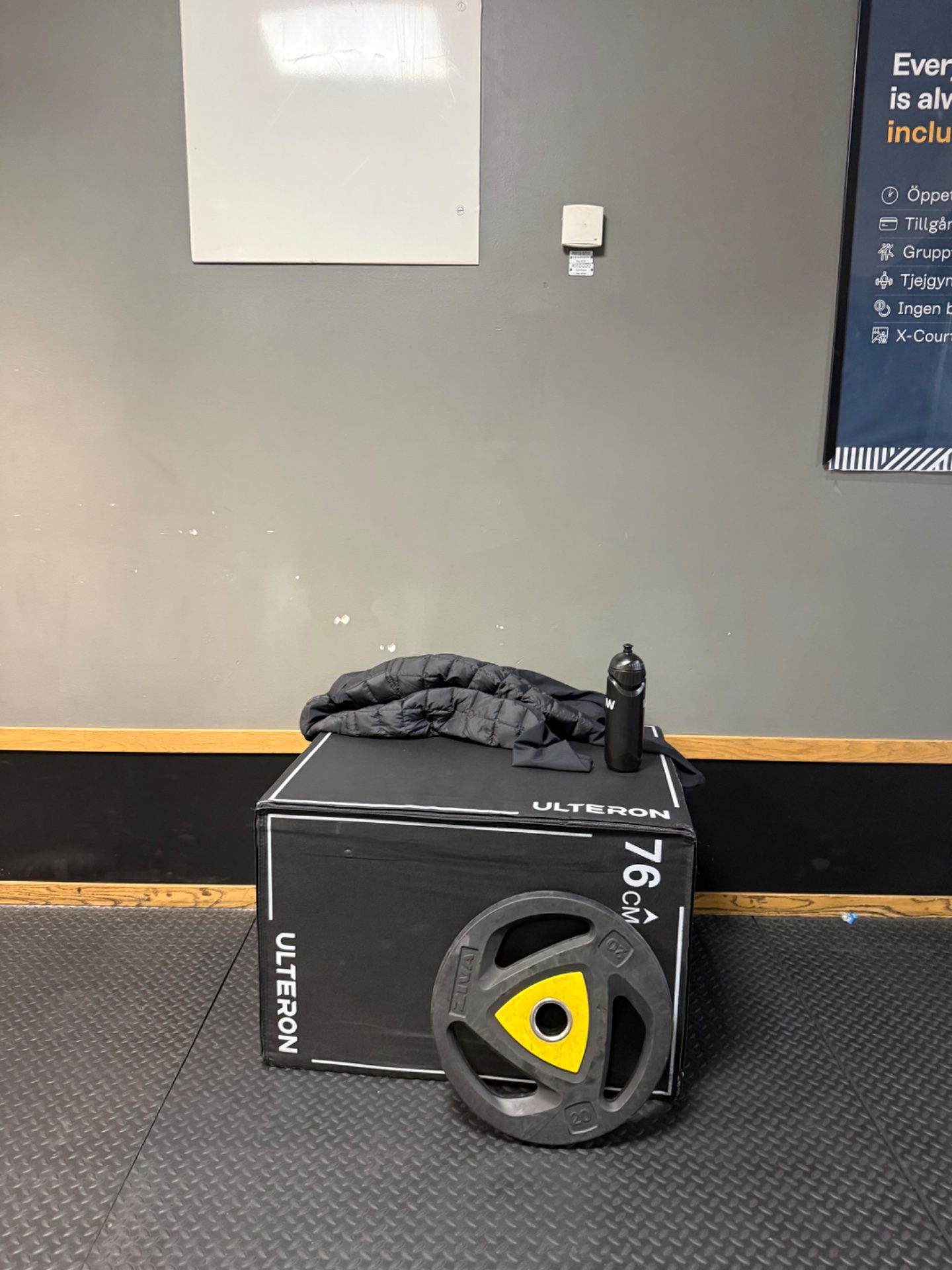 Gym setup with weight plates and resistance training equipment displayed at a fitness facility. Shows strength training gear ready for a workout session.