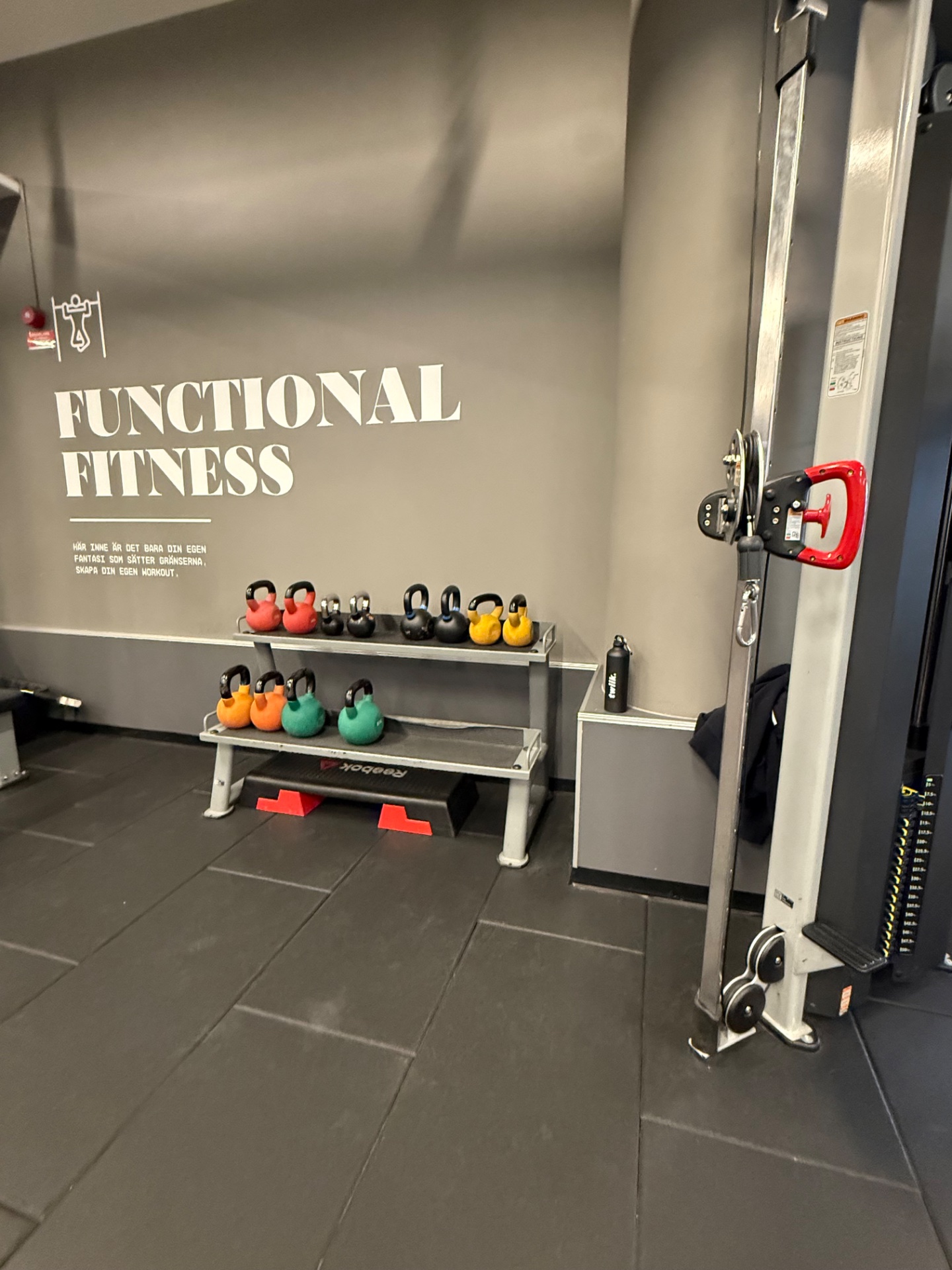 A functional fitness gym setup featuring kettlebells, dumbbells, and resistance training equipment ready for an intense strength and conditioning session!