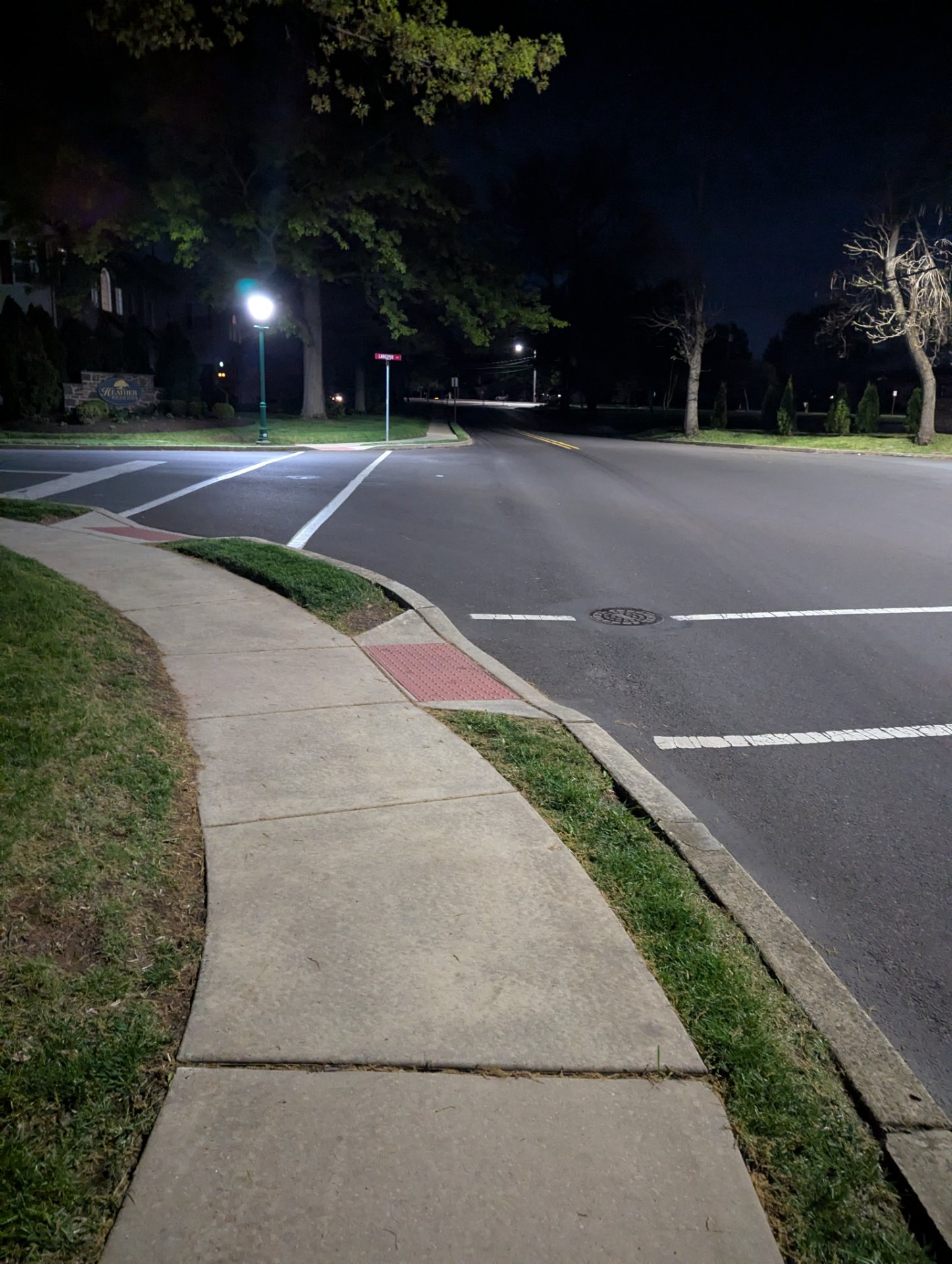 An evening run or walk through a well-lit neighborhood street with sidewalks and street lighting. Perfect conditions for outdoor cardio training at night!