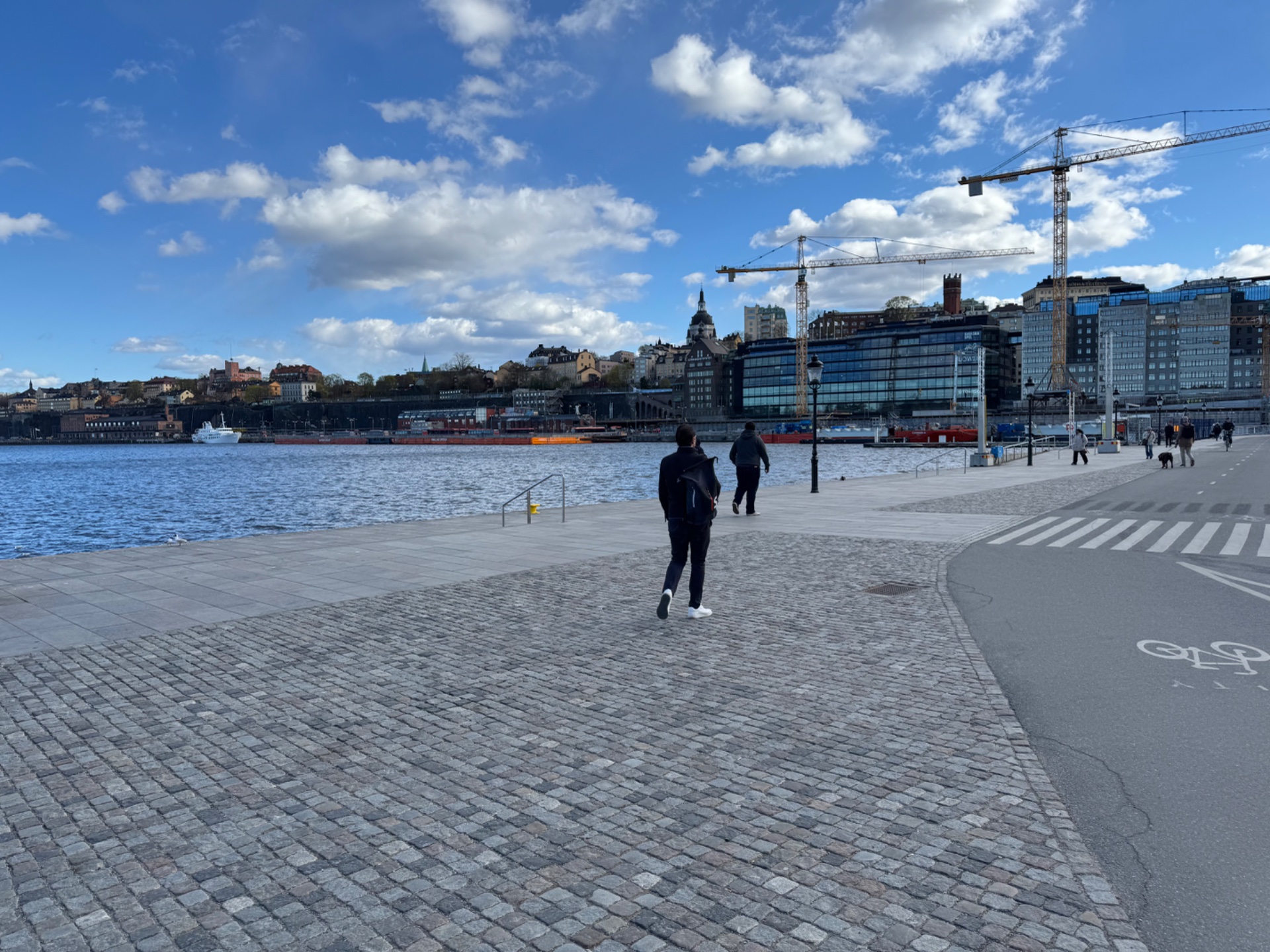 A scenic waterfront run along what appears to be a Stockholm waterfront promenade, with beautiful urban views and blue skies creating an ideal outdoor cardio session!