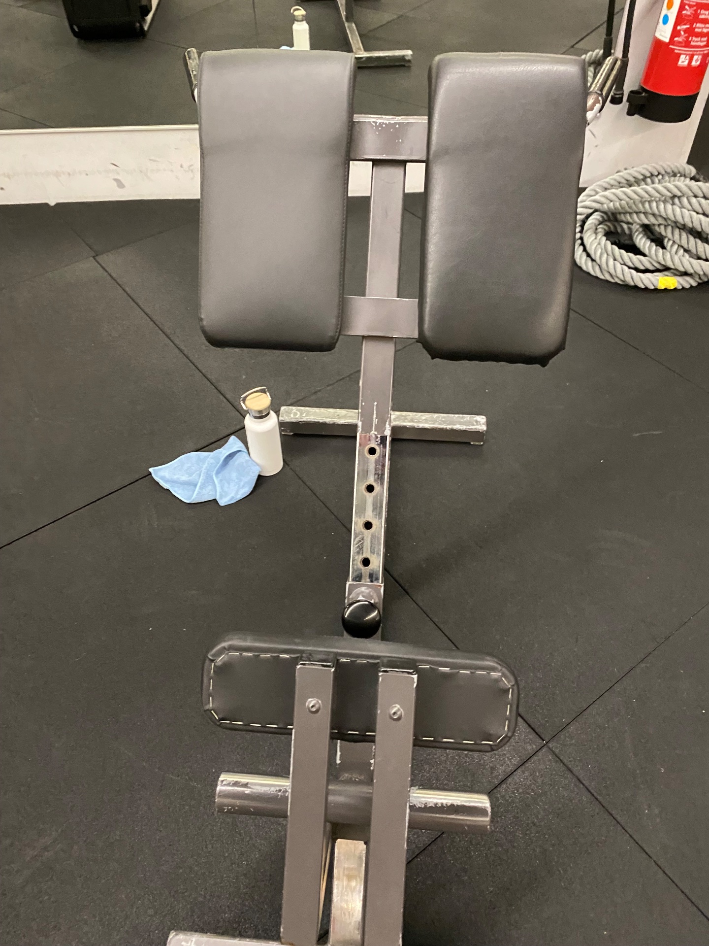 A gym setup featuring a chest press or shoulder press machine with padded handles, ready for resistance training. This is classic strength training equipment for building upper body muscle.