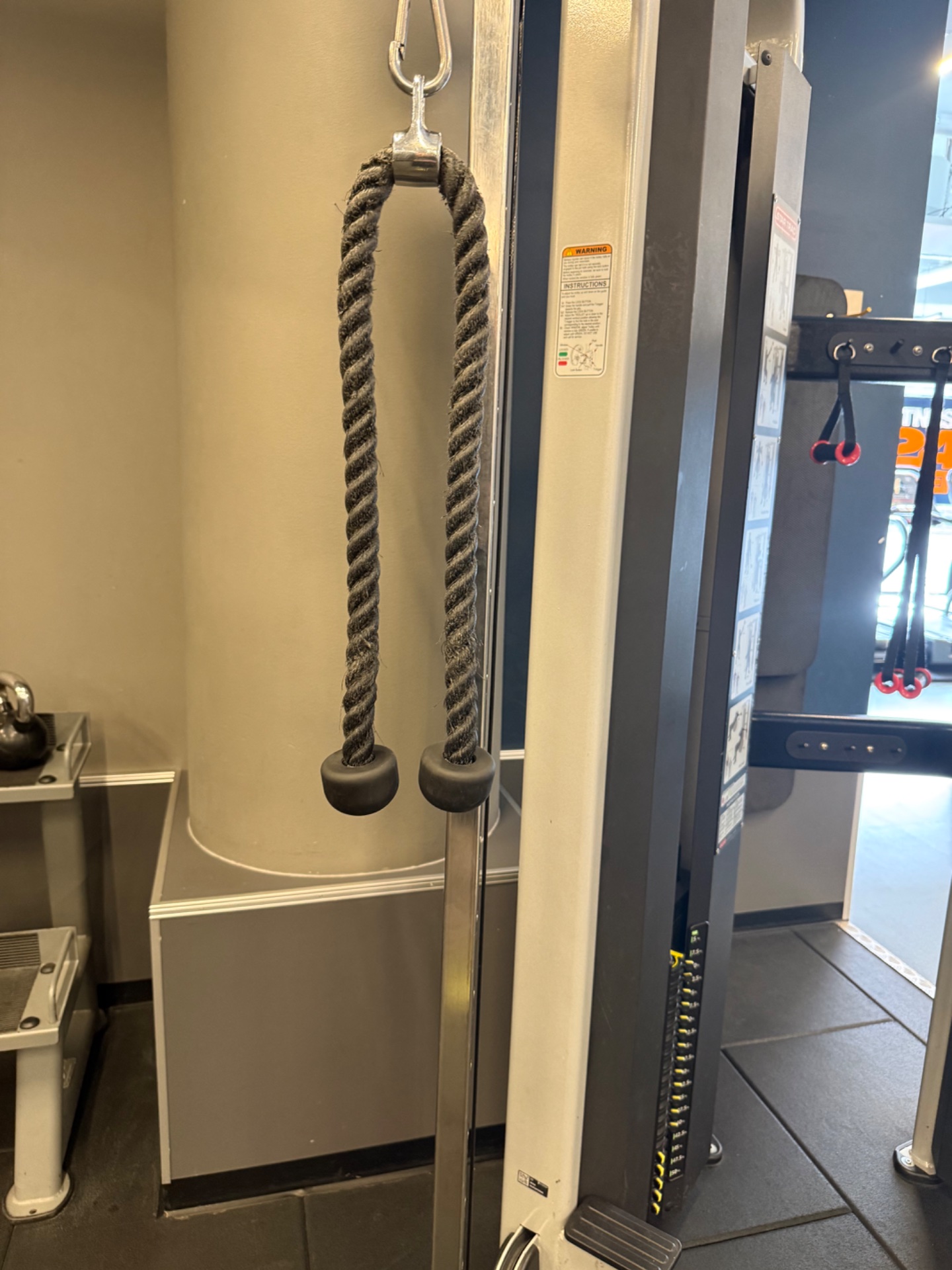 Gym equipment setup featuring rope attachments on a cable machine, perfect for functional strength training and resistance exercises. This is classic gym infrastructure for pulling and pushing movements.