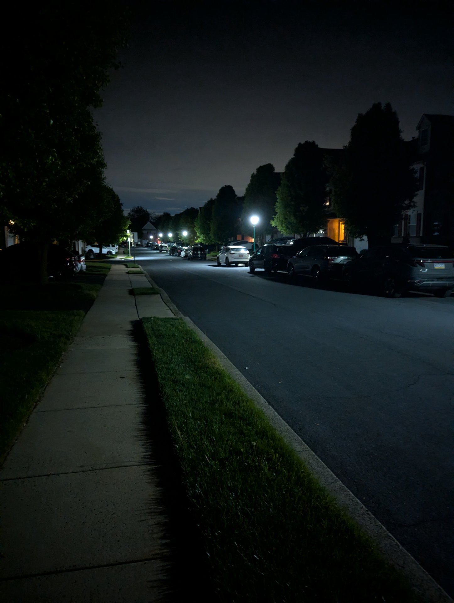 Evening walk or run down a quiet residential street with good lighting and tree-lined sidewalks—perfect conditions for outdoor cardio!