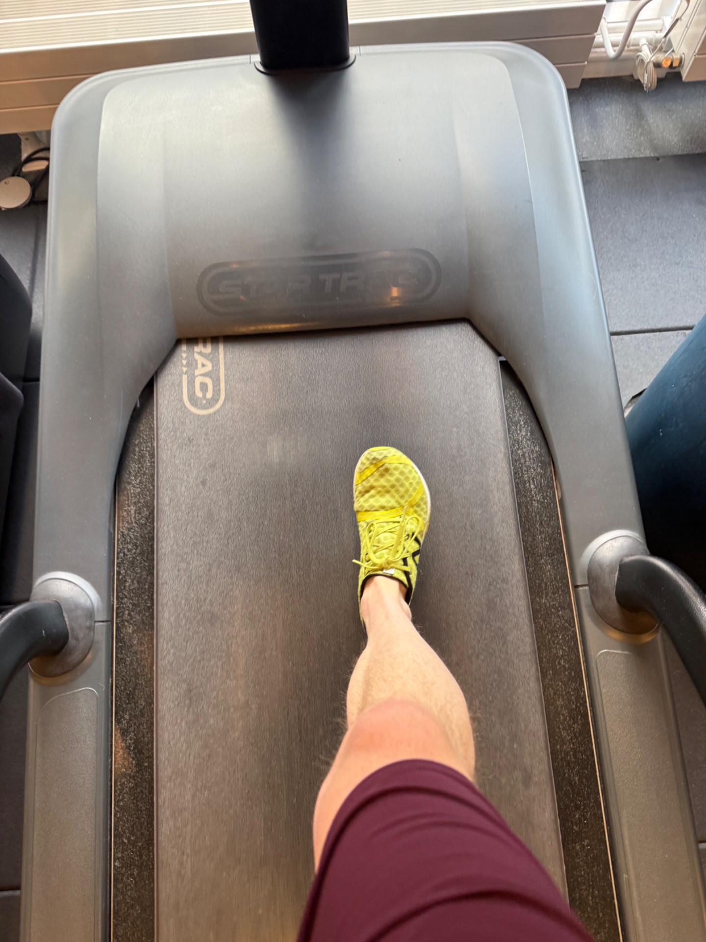 Treadmill running session captured from a first-person perspective, showing bright yellow running shoes and athletic wear. Great cardio workout!