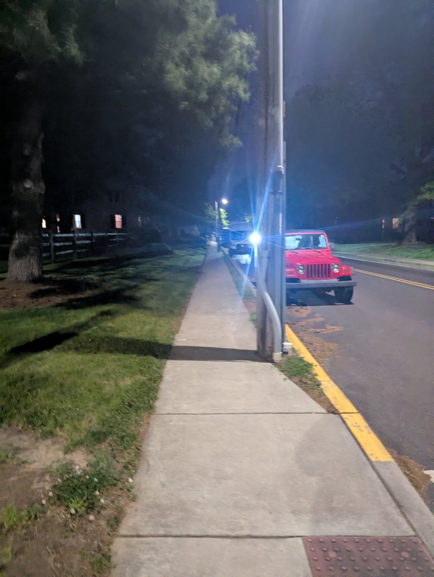 Evening walk or run on a sidewalk along a tree-lined residential road, captured at night with street lighting.
