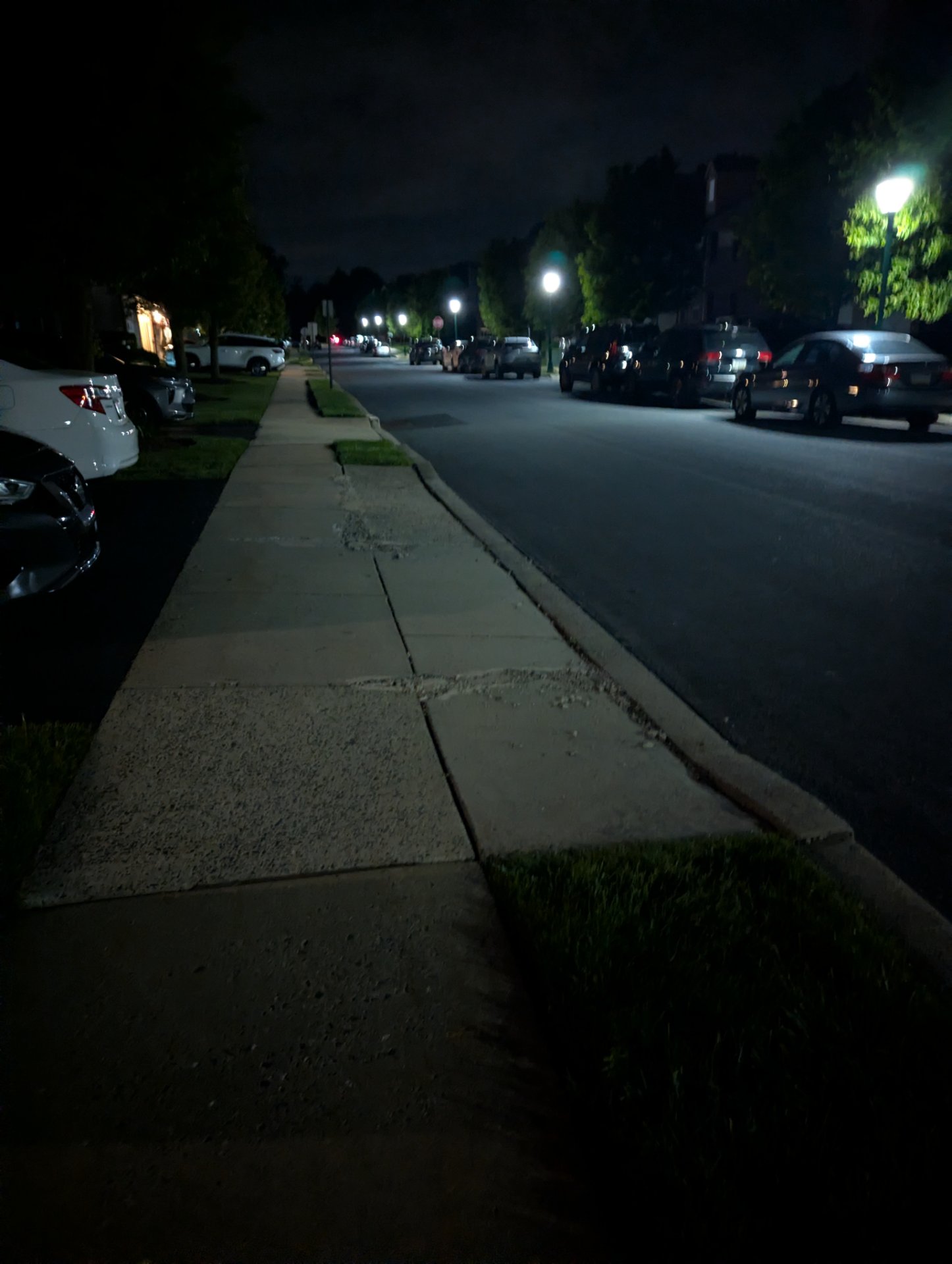 A nighttime neighborhood walk or run along a quiet residential street with sidewalks and street lighting. Perfect for an evening cardio session!