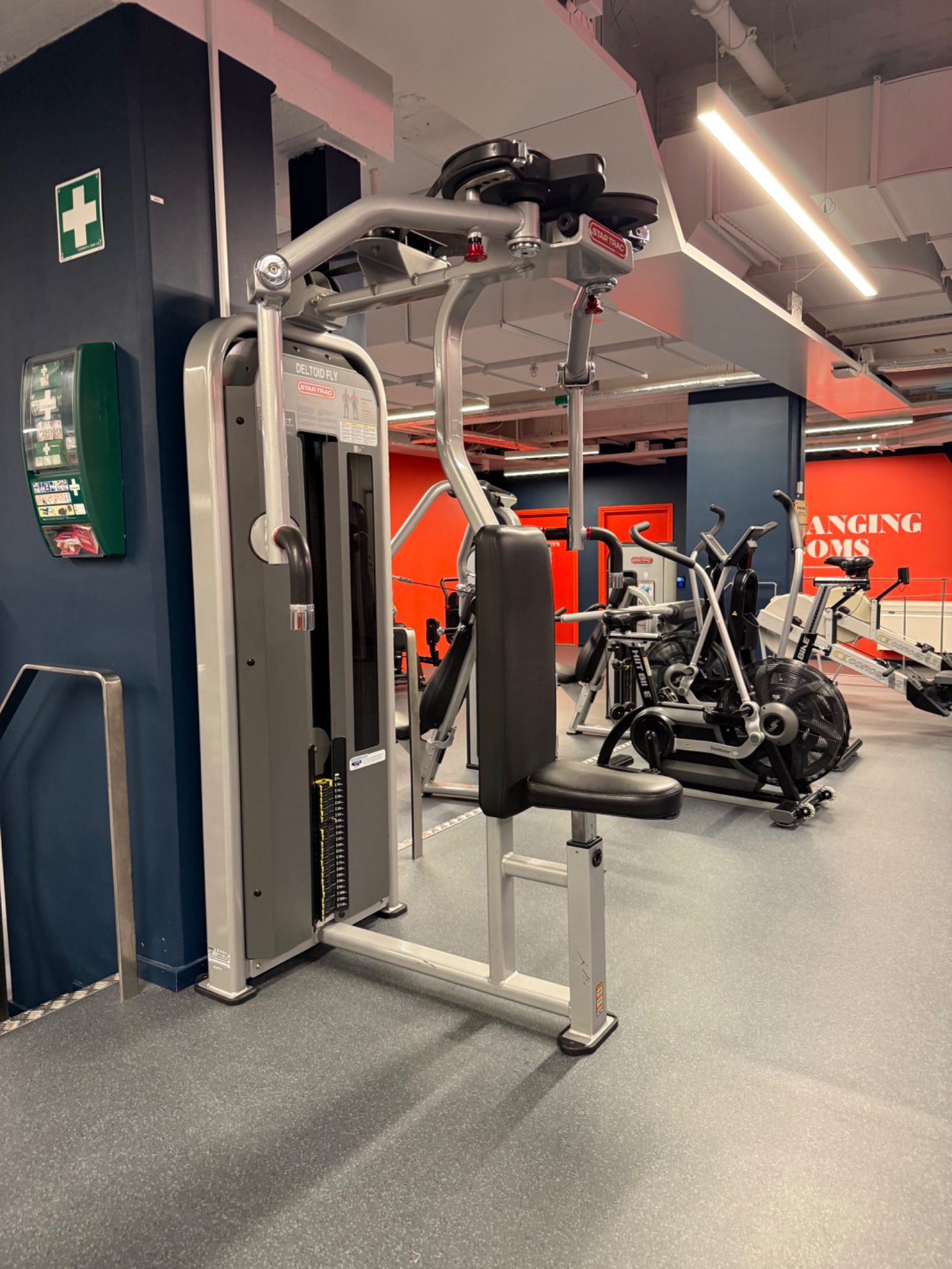 A gym facility featuring a leg press machine and stationary bikes in the background. This appears to be a modern fitness center with both cardiovascular and strength equipment available for workouts.