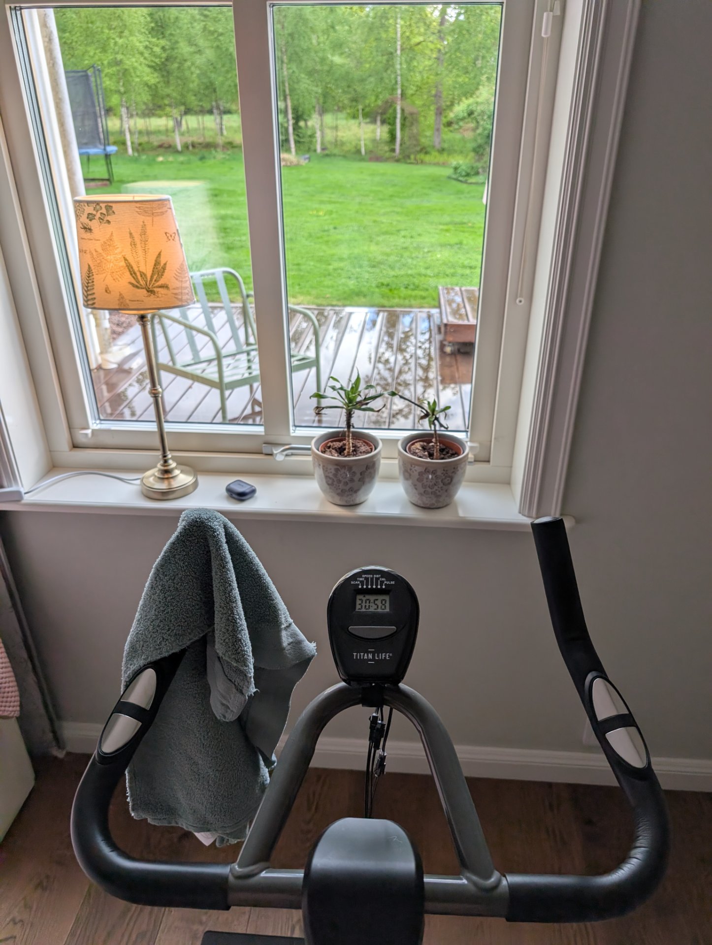 Indoor cycling session on a stationary bike with a Titan Life performance monitor tracking workout metrics. A great way to get a solid cardio workout from home!