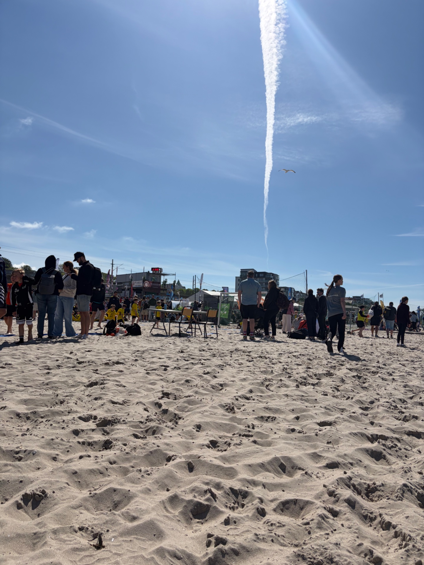 Beach volleyball tournament or recreational game with multiple players and spectators enjoying an outdoor activity on the sand. Great cardiovascular workout with dynamic movement and competition!