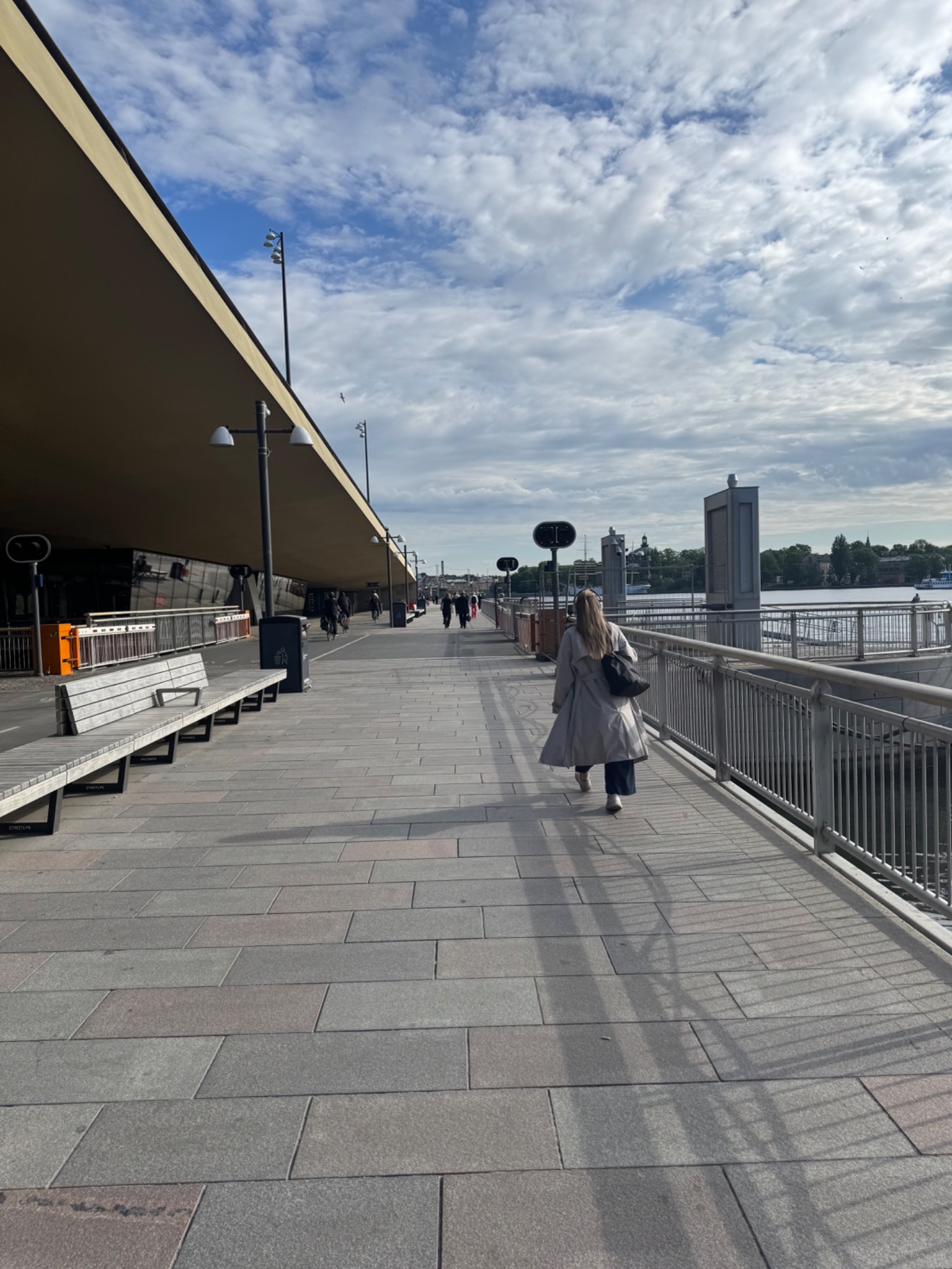 A scenic waterfront walk along a modern promenade with beautiful views of the water and cityscape. Perfect for getting steps in while enjoying the outdoors!