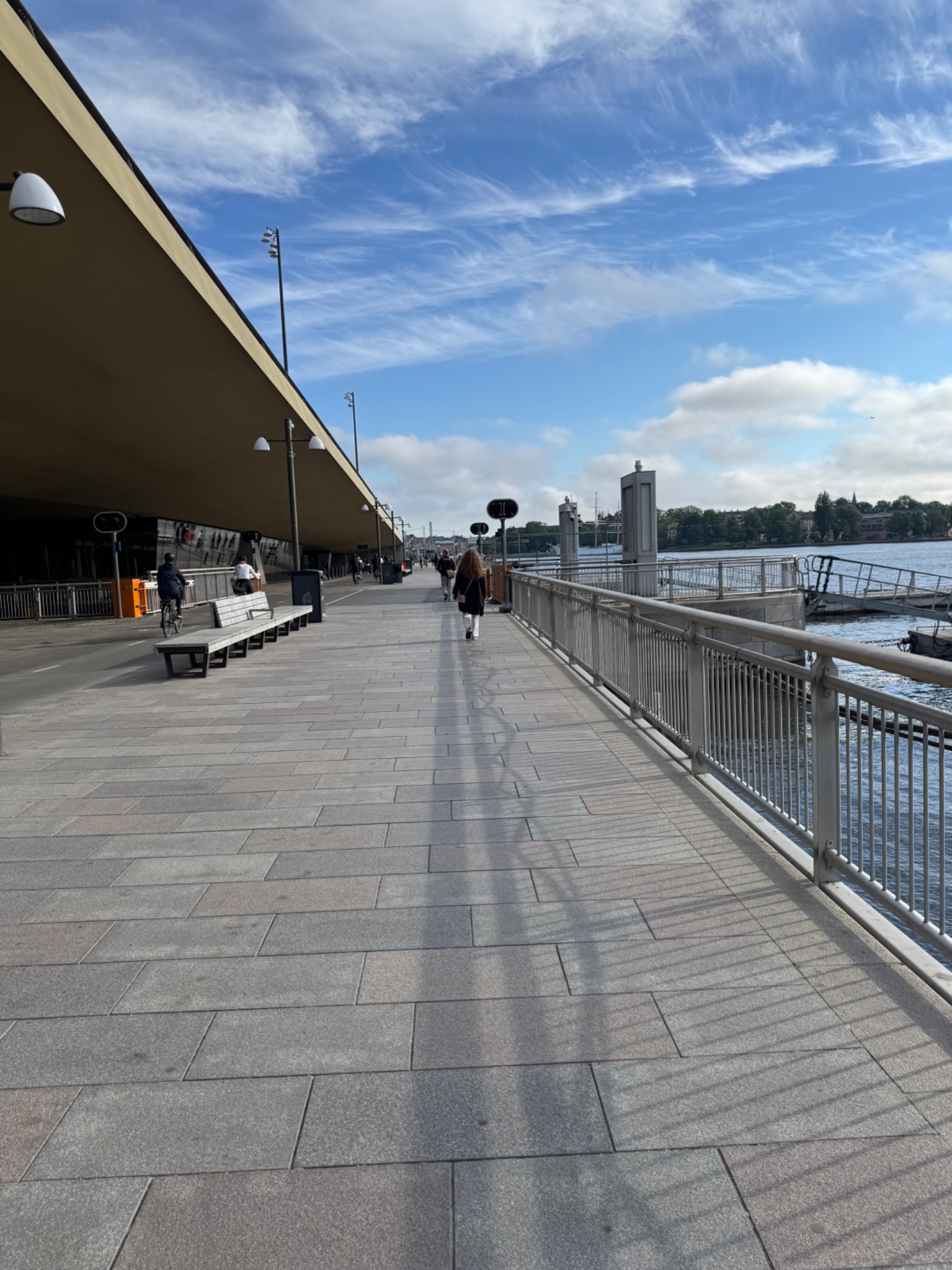 A scenic waterfront walk or jog along a modern waterside promenade with beautiful views of the water and cityscape. Perfect for an outdoor cardio session in a picturesque urban setting!