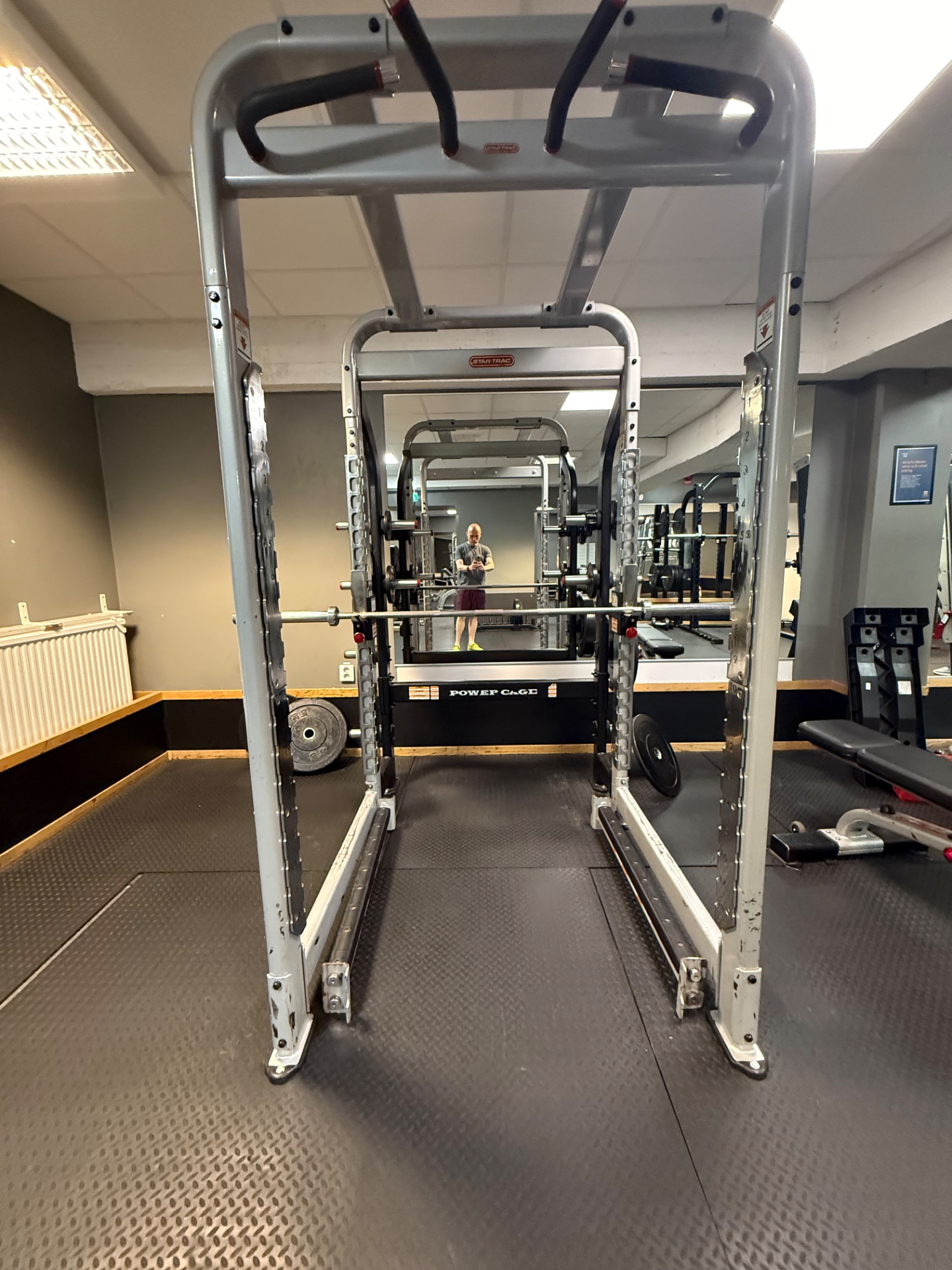 A gym setting showcasing a power rack and various resistance training equipment, perfect for weightlifting and strength workouts!