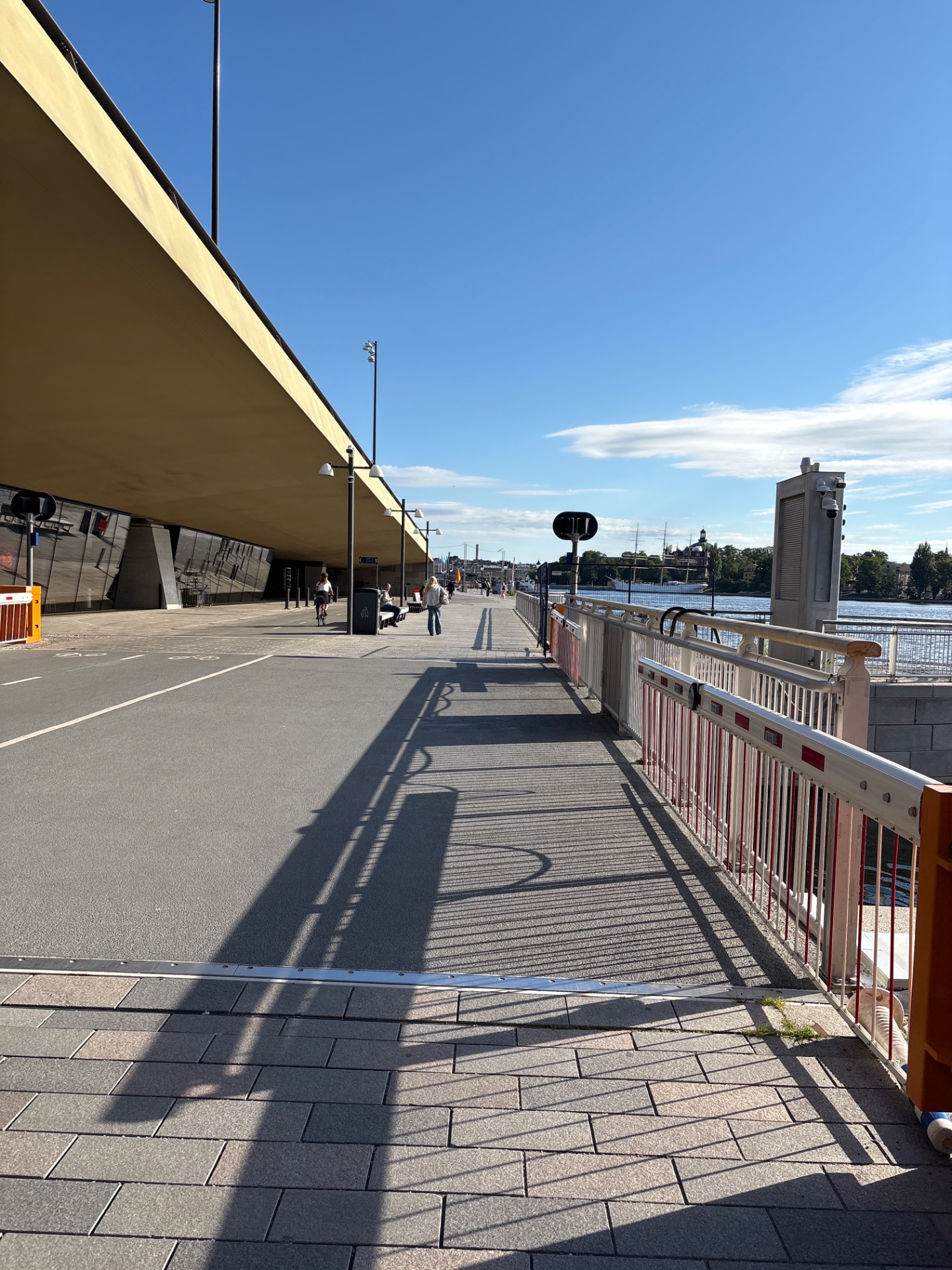 An outdoor waterfront walk or stroll along a scenic promenade with beautiful views of the water and city skyline. Perfect for a leisurely cardio session in a great urban setting!